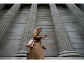 A pedestrian walks past the Bank of England (BOE) in the City of London, U.K., on Thursday, March 18, 2021. The Bank of England is likely to emphasize its high bar for tightening monetary policy, a move to tamp down speculation that a quick recovery will force policy makers to push U.K. borrowing costs higher.