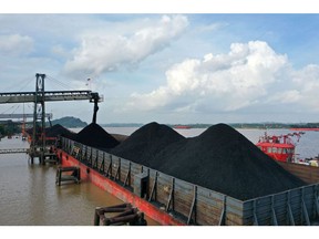 Coal is loaded onto a barge at a terminal operated by PT Bara Kumala Sakti in Kutai Kartanegara, East Kalimantan, Indonesia, on Wednesday, Oct. 13, 2021. Coal prices are likely to remain high after soaring to new records on strengthening power demand and challenges in key supplier nations, according to a major Australian producer.