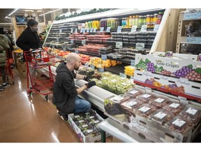 An employee restocks shelves with cases of grapes at the Trader Joe's Upper East Side Bridgemarket grocery store in New York, U.S., on Thursday, Dec. 2, 2021. The century-old vaulted market under the Queensboro Bridge has reopened on Thursday as a Trader Joe's.