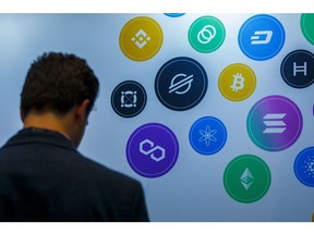 An attendee near logos of different cryptocurrencies at the CryptoCompare Digital Asset Summit at Old Billingsgate in London, U.K., on Wednesday, March 30, 2022. Bitcoin and other cryptocurrencies had been, up until the last few weeks, mired in a similar downtrend as other riskier assets, like U.S. stocks.