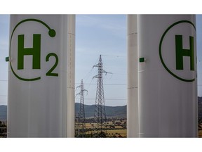 High voltage electricity transmission towers beyond hydrogen storage tanks during the final stages of construction at Iberdola SA's Puertollano green hydrogen plant in Puertollano, Spain, on Thursday, May 19, 2022. The new plant will be Europe's largest production site for green hydrogen for industrial use. Photographer: Angel Garcia/Bloomberg