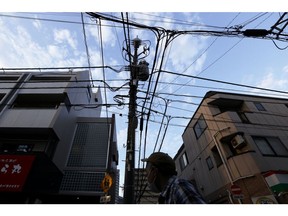 A utility pole and power lines in Tokyo, Japan, on Friday, July 1, 2022. The government issued a heat stroke alert for several regions in the country including the nations capital, urging people to take health precautions amid scorching temperatures. Photographer: Kiyoshi Ota/Bloomberg