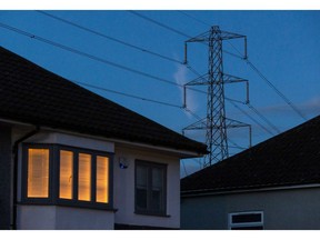 A light on at a residential home near an electricity transmission tower in Upminster, UK, on July 4.