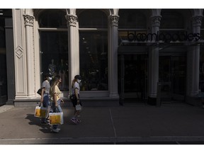 Shoppers carry Aritzia bags past a Bloomingdale's store in the Soho neighborhood of New York, US, on Thursday, July 28, 2022. Consumer spending slowed to a 1% annualized growth rate from 1.8% for the first quarter. Photographer: Victor J. Blue/Bloomberg
