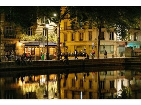 Buildings lit by street lights are reflected in the the Canal Saint-Martin at night in Paris, France, on Thursday, July 28, 2022. Although economic expansion in France beat expectations by a distance, the European energy crisis is pushing up the cost of electricity in the wholesale market for the whole of Europe, with French forward prices surging to almost 1,000% more than their decade-long average through 2020. Photographer: Benjamin Girette/Bloomberg