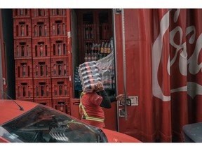 A worker unloads Coca-Cola bottles from a truck at a market in Toluca, Mexico state, Mexico, on Tuesday, Aug. 9, 2022. Soaring prices of food and fuel across Latin America are hitting the poor the hardest, creating a political tinderbox that's a warning to the world.