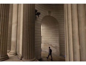 A commuter passes through arches of the Bank of England (BOE) in the City of London, UK, on Monday, Oct. 17, 2022. The Bank of England said it was restarting its corporate bond-selling as it looks to return to normality in the wake of a sustained selloff in UK assets. Photographer: Jason Alden/Bloomberg