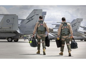 AMBERLEY, AUSTRALIA - SEPTEMBER 21: In this handout image provided by Commonwealth of Australia, F/A-18F Super Hornet aircrew head to their aircraft in preparation for departure to the Middle East from RAAF Base Amberley on September 21, 2014 in Amberley, Australia. The main contingent of Royal Australian Air Force personnel and aircraft has departed for the Middle East today. Approximately 600 troops will be based on standby in United Arab Emirates for action in Iraq.