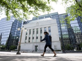 A woman walks past the Bank of Canada headquarters, Wednesday, June 1, 2022 in Ottawa. The Bank of Canada is expected to announce another hefty hike of its key interest rate on Wednesday morning, continuing one of the fastest monetary policy tightening cycles in its history, despite the growing warning signs of a potential recession.