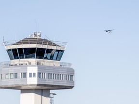 A view of the air traffic control tower at Flesland Airport as a small propeller plane flies in background, in Bergen, Norway, Wednesday, Oct. 19, 2022. Authorities say the airport in Norway's second-largest city has briefly closed after at least one drone was spotted nearby by area residents. A police spokesman said the first drone sighting at Bergen Airport was reported at 4:15 a.m. on Wednesday.