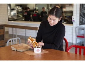 Stoney Creek resident and Arby's employee Cecilia tries the Poutine Dip Sandwich for the first time. Arby's Canada brings back its audaciously tasty and decidedly Canadian sandwich creation on November 7. Photo credit: Arby's Canada, Chris Young