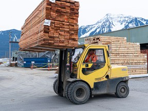 A forklift moves a stack of lumber at a mill in British Columbia. Retail, wholesale trade, agriculture, and the public sector all grew in August while construction, manufacturing and mining, quarrying and oil and gas extraction contracted.