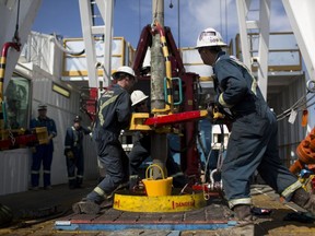 Mitarbeiter ziehen ein Rohr an einem Keilbohrloch am Christina Lake fest, einer Situ-Ölförderanlage, die zur Hälfte Cenovus und ConocoPhillips in Alberta gehört.