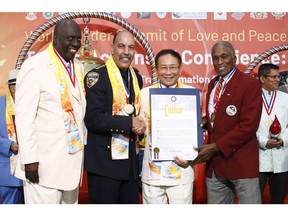 Dr. Hong, Tao-Tze, president of FOWPAL, is honored by New York City Mayor with a citation. From left, Harlem Globetrotter Robert Richard, New York City Sheriff Anthony Miranda, Dr. Hong, and Johnny Ford, president of the World Conference of Mayors. (AP Images)