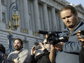 David DePape, right, records the nude wedding of Gypsy Taub outside City Hall on Dec. 19, 2013, in San Francisco. DePape is accused of breaking into House Speaker Nancy Pelosi's California home and severely beating her husband with a hammer. DePape was known in Berkeley, Calif., as a pro-nudity activist who had picketed naked at protests against local ordinances requiring people to be clothed in public.