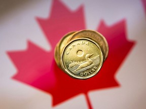Canadian dollar coins against Canada's flag.