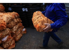 A supplier unloads bags of firewood at the Hans Engelke Energie OHG depot in Berlin, on Oct. 5. Photographer: Krisztian Bocsi/Bloomberg