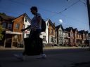 A person walks past a row of houses in Toronto.