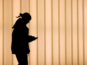 A woman walks inside of the World Trade Center while using a cell phone in New York.