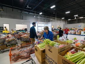 Volunteers put together a hamper of fresh and canned foods at the Calgary Food Bank on Oct. 26, 2022.