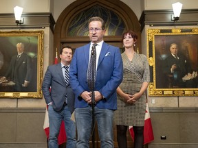 Bloc MP for La Prairie Alain Therrien, left, and MP for Saint-Jean Christine Normandin look on as leader Yves-Francois Blanchet speaks with reporters following the defeat of a motion on ties to the monarchy in Ottawa.