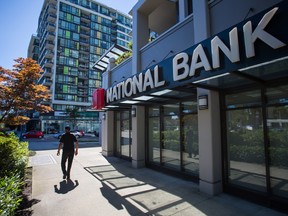 A pedestrian passes in front of a National Bank of Canada branch in Richmond, B.C.