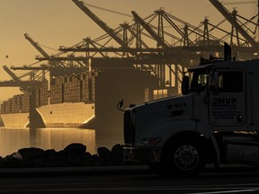 FILE - A truck arrives to pick up a shipping container near vessels at the Port of Los Angeles, on Nov. 30, 2021. An influential government advisory panel comprised of major U.S. businesses is proposing new rules that would roll back already limited public access to import data, a move that trade experts say would make it harder to trace labor abuse by foreign suppliers. The proposal, if adopted, would shroud in secrecy customs data on ocean-going freight responsible for about half of the $2.7 trillion worth of goods entering the U.S. every year in the same way it already is for rail, truck and air cargo.
