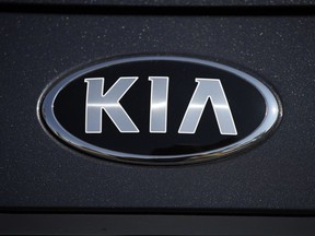 FILE - The company logo shines off the hood of a 2021 K5 sedan on display in the Kia exhibit at the Denver auto show Friday, Sept. 17, 2021, at Elitch's Gardens in downtown Denver. Kia is telling owners, Wednesday, Oct. 26, 2022, of nearly 72,000 older Sportage small SUVs in the U.S. to park them outdoors and away from structures after getting reports of more engine fires. It's the second time that Sportages from the 2008 and 2009 model years have been recalled due to fire risks that apparently can start near a hydraulic engine control device.
