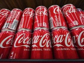 FILE - Cans of Coca-Cola are on display at a grocery market in Uniontown, Pa., April 24, 2022. The soft drink giant's sponsorship of the flagship U.N. climate conference, known as COP27, sparked an online backlash and highlighted broader concerns about corporate lobbying and influence.