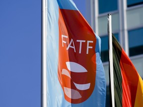 FILE - A flag with the logo of the Financial Action Task Force, FATF, waves in the wind next to the German national flag during a meeting of the task force at the Congress Center in Berlin, Germany, Friday, June 17, 2022. An international watchdog said Friday Oct.21, 2022 it is removing Pakistan from its so-called "gray list" of countries that do not take full measures to combat money laundering and terrorism financing