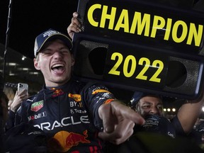 Red Bull driver Max Verstappen of the Netherlands celebrates with teammates as he became F1 drivers world champion, during the Japanese Formula One Grand Prix at the Suzuka Circuit in Suzuka, central Japan, Sunday, Oct. 9, 2022.