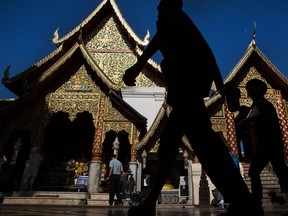A group of tourists walk past a temple in Thailand. The country is among countries investors may want to focus on.