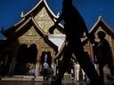 A group of tourists walk past a temple in Thailand.  The country is among the countries that investors could focus on.