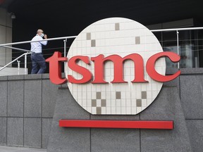 FILE - A person walks into the Taiwan Semiconductor Manufacturing Co., Ltd. (TSMC) headquarters in Hsinchu, Taiwan on Oct. 20, 2021. Taiwan Semiconductor Manufacturing Co., the biggest contract manufacturer of processor chips for smartphones and other products, said Thursday, Oct. 13, 2022, quarterly profit rose 79.7% over a year earlier to $8.8 billion amid surging demand.