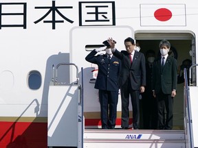 Japanese Prime Minister Fumio Kishida, center, waves as his departure for Australia, at Haneda international airport in Tokyo, Friday, Oct. 21, 2022. Kishida, heading to Australia for talks with his Australian counterpart, Anthony Albanese, said Friday that he wants to bolster military and energy cooperation between the two countries that are increasingly getting closer over shared concern about China's rise.