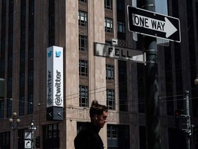 a person walks past the Twitter headquarters in downtown San Francisco.