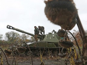 Ukrainian artillerymen stand on their self-propelled 152 mm gun SAU 2S3 Akatsiya at a position on the front line with Russian troops in Donetsk region on October 11. Photographer: Anatolii Stepanov/AFP/Getty Images