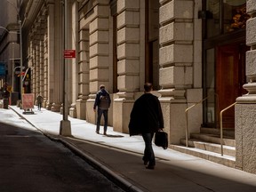 Pedestrians walk along a street in the financial district of New York.