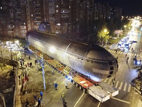The bow of the Soviet submarine K-3 'Leninsky Komsomol' is transported by a platform along the street from the pier to the museum where it will be assembled with the stern and installed as a museum, in the city of Kronstadt, outside St. Petersburg, Russia, Wednesday, Oct. 12, 2022. K-3 'Leninsky Komsomol' (NATO reporting project name "November"), the first nuclear submarine of the Soviet Union was built in 1957 and based in Soviet Navy's Northern Fleet in Murmansk region. In 1967, while transiting the Norwegian Sea, 39 crew members of K-3 died in bow compartments in the fire.
