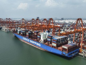 In this photo released by Xinhua News Agency, aerial photo shows a container ship berthed at the container wharf of Qinzhou Port in Qinzhou in southern China's Guangxi Zhuang Autonomous Region on Sept. 13, 2022. China reported Monday, Oct. 24, 2022 economic growth rises to 3.9% over a year ago in latest quarter, up from 0.4% in previous quarter.