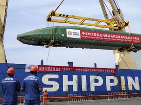 In this photo released by Xinhua News Agency, a high-speed electric passenger train, customized for the Jakarta-Bandung High-Speed Railway (HSR) project, is loaded onto a vessel in Qingdao Port in eastern China's Shandong Province, Aug. 18, 2022. China reported Monday, Oct. 24, 2022 economic growth rises to 3.9% over a year ago in latest quarter, up from 0.4% in previous quarter.