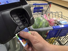 A customer buys groceries with a credit card in Salem, N.H.,&ampnbsp;July 17, 2018. The head of the Canadian Bankers Association says more consumer protection is needed as new entrants in the fast-growing payments space get ahead of regulation.