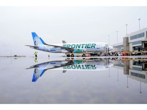 A Frontier Airlines Inc. plane is reflected in a puddle on the tarmac at Denver International Airport (DIA) in Denver, Colorado, U.S., on Tuesday, April 4, 2017. Frontier Airlines Inc., the no-frills U.S. carrier whose aircraft feature animals on the tails, is aiming to go public as soon as the second quarter, people with knowledge of the matter said.