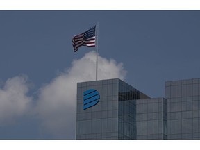 An American flag flies on top of the Dominion Energy headquarters in Richmond, Virginia, U.S., on Monday, July 6, 2020. Dominion Energy, the second-biggest U.S. power company by market value, on Sunday said it's selling substantially all of its gas pipeline and storage assets to Berkshire Hathaway Inc. for $4 billion.