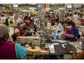 Workers sew garments on machines at the Prestige Clothing (Pty) Ltd. textile factory, operated by The Foschini Group Ltd., in the Maitland district of Cape Town, South Africa, on Thursday, Dec. 10, 2020. South African retailers including The Foschini Group and Woolworths Holdings Ltd. are increasing investment in local clothing manufacturers -- both to reduce a dependency on Chinese imports and secure a supply chain thrown into disarray by Covid-19 restrictions. Photographer: Dwayne Senior/Bloomberg