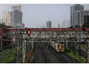A train travels through Parel railway station in Mumbai, India, on Friday, June 18, 2021. Economists see the Reserve Bank of India taking a grin-and-bear it approach to price pressures as it seeks to help Asia's No. 3 economy recover from one of the world's worst coronavirus outbreaks.