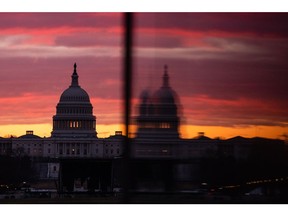 The U.S. Capitol is reflected in an entrance to the Washington Monument at sunrise in Washington, D.C., U.S., on Tuesday, Jan. 18, 2022. The Senate returns today to take up Democrats' voting rights and election-overhaul legislation, a likely doomed effort amid party disunity over changing longstanding Senate rules.