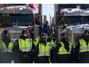 Police form a line to push back protesters as they begin clearing the trucker convoy out of downtown Ottawa on Feb. 18, 2022.