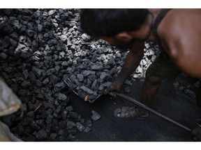 A worker loads coal into a sack at a coal wholesale market in Mumbai, India, on Thursday, May 5, 2022. Production of coal, the fossil fuel that accounts for more than 70% of India's electricity generation, has failed to keep pace with unprecedented energy demand from the heat wave and the country's post-pandemic industrial revival. Photographer: Dhiraj Singh/Bloomberg