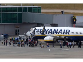 Passengers board an aircraft, operated by Ryanair Holdings Plc, on the tarmac at London Stansted Airport, operated by Manchester Airport Plc, in Stansted, U.K., on Monday, July 25, 2022. Ryanair said passengers remain cautious about booking, clouding its prospects beyond a summer travel boom in which it's suffering less disruption than many of its rivals. Photographer: Chris Ratcliffe/Bloomberg